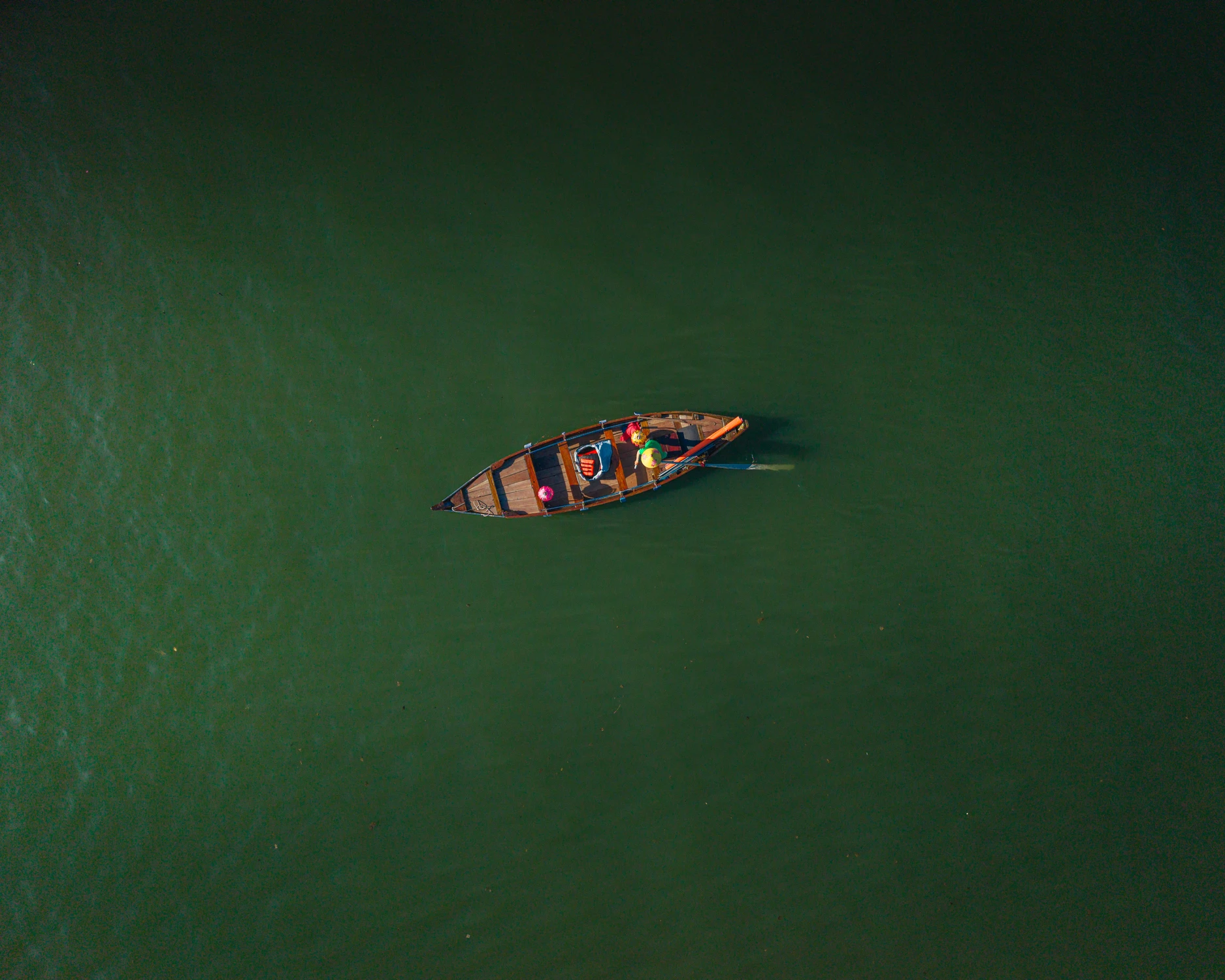 Solitary wooden boat on green water