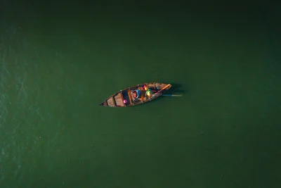 Solitary wooden boat on green water