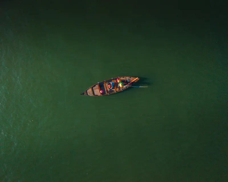 Solitary wooden boat on green water